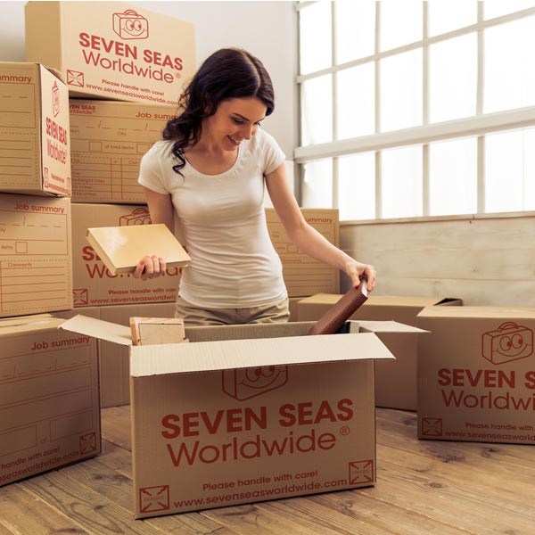 Woman packing books into shipping boxes
