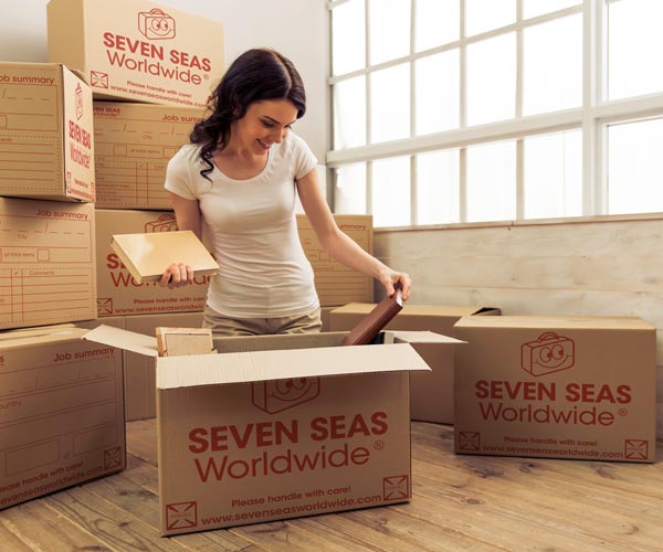 Woman packing books into boxes for shipping