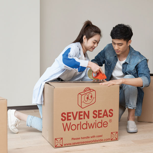 Couple sealing a cardboard box